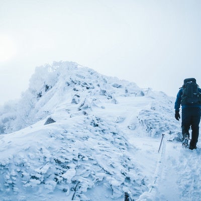 厳冬期の天狗岳の頂上を目指す登山者の写真