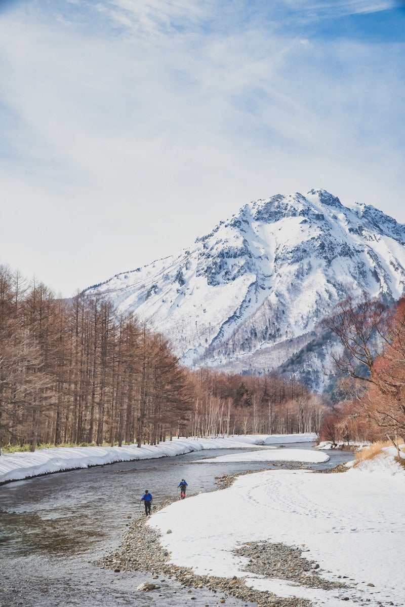 梓川の河畔を歩く登山者（上高地）の写真