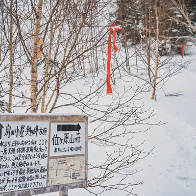 雪の中の位ヶ原山荘への看板と道しるべ（乗鞍岳）の写真