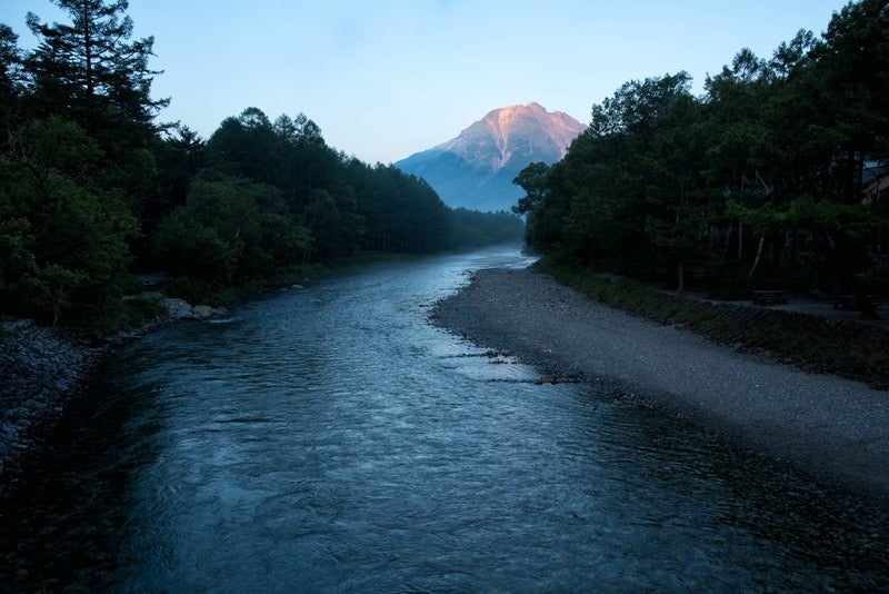 朝焼けに染まる焼岳に続く梓川の写真