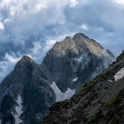 沸き立つ雲から顔を出す前穂高岳の写真