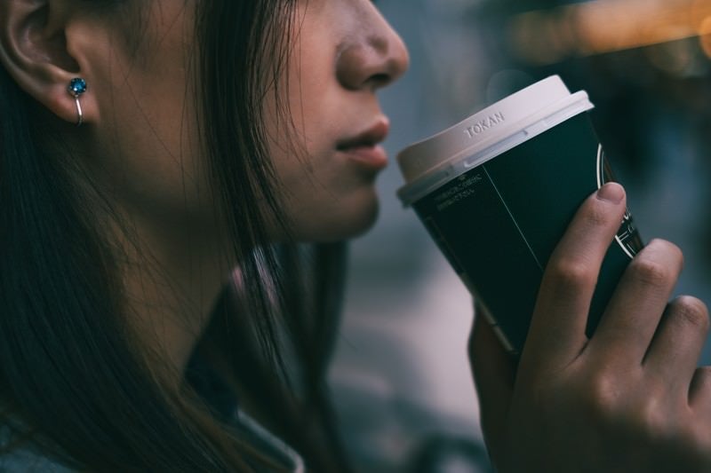 コーヒータイムの女性の口元の写真