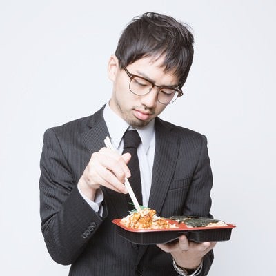 のり弁当を食べる会社員の写真