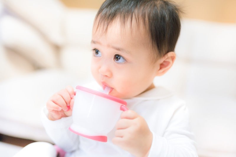 ジュースを飲むと上機嫌の赤ちゃんの写真