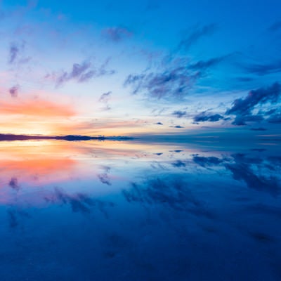 沈む夕日とグラデーションの夕焼け（ウユニ塩湖）の写真