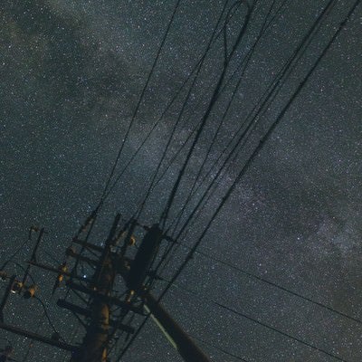 電柱のシルエットと輝く星空の写真