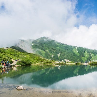 湖の周りでカメラを構える登山者達の写真