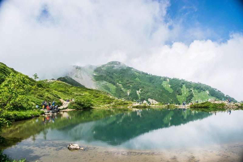 湖の周りでカメラを構える登山者達の写真