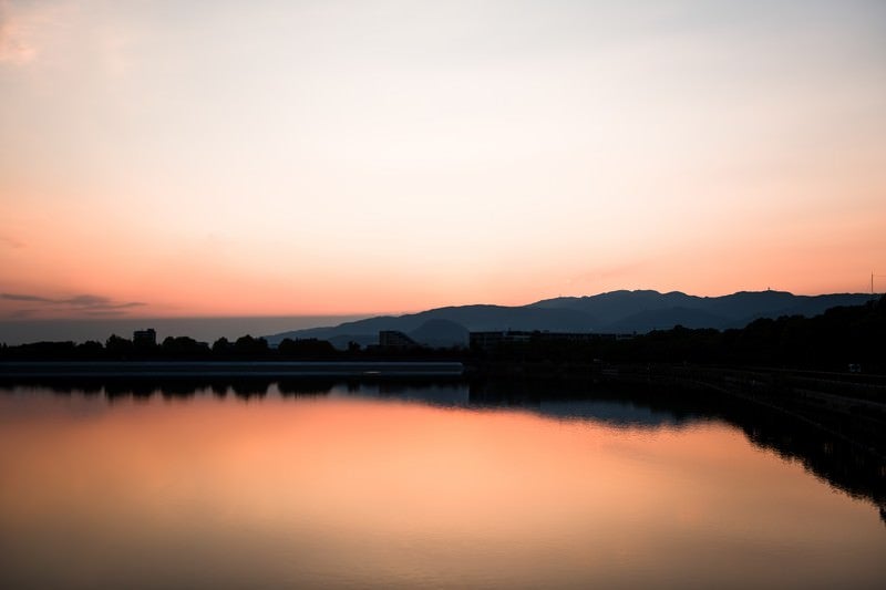 夕暮れと反射する水面の写真