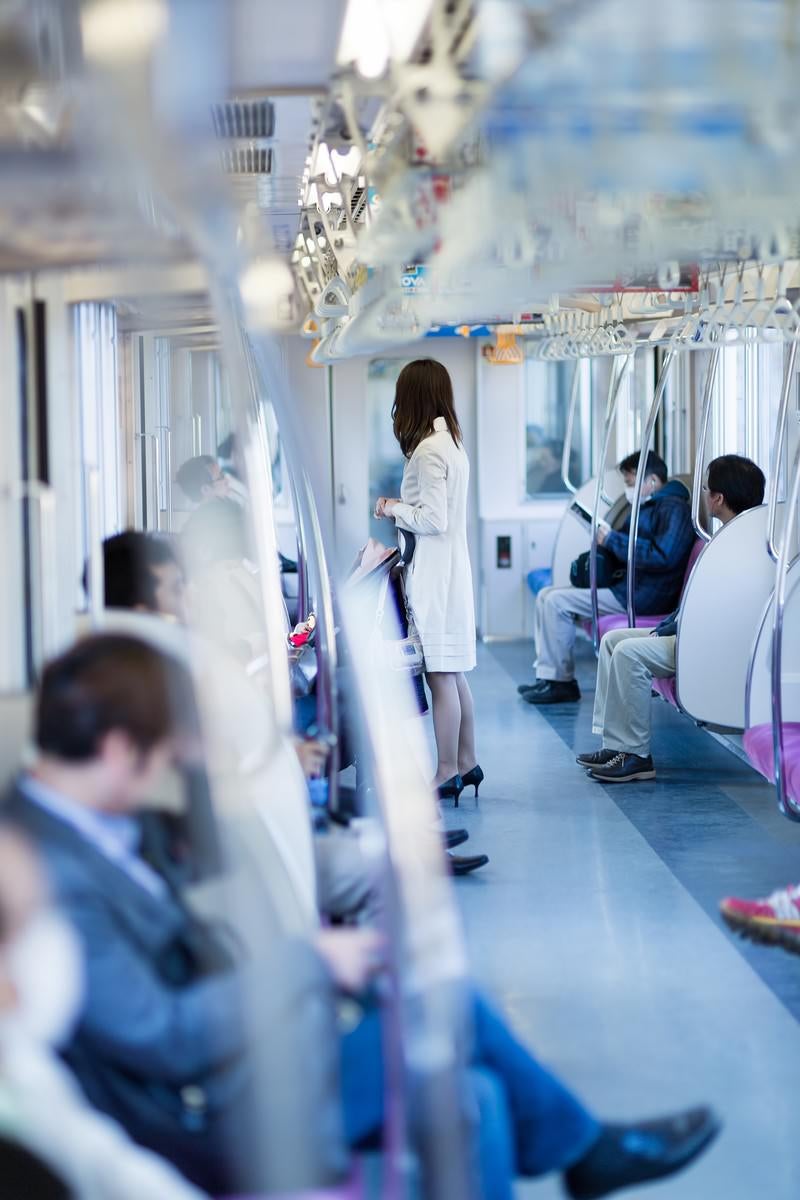 電車に乗るハイヒールの女性の写真