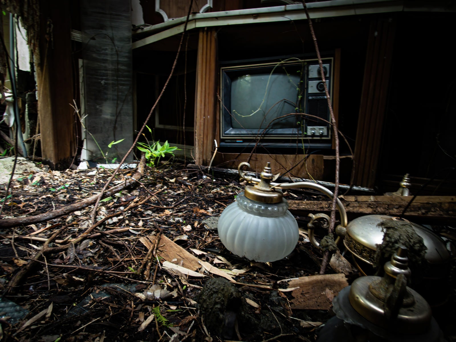 「剥き出しの地面に落ちた照明器具」の写真