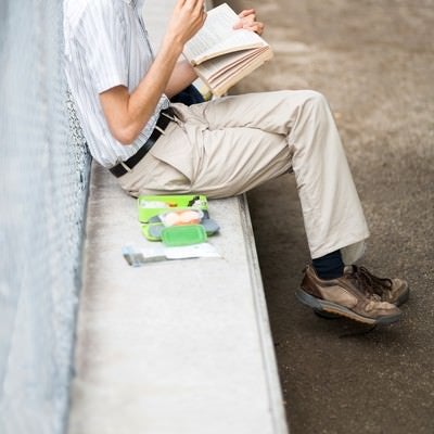 お食事しながら本を読む男性の写真