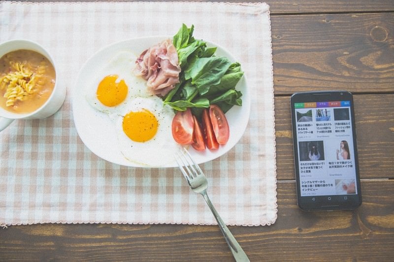 ニュースを見ながら朝食を食べるの写真