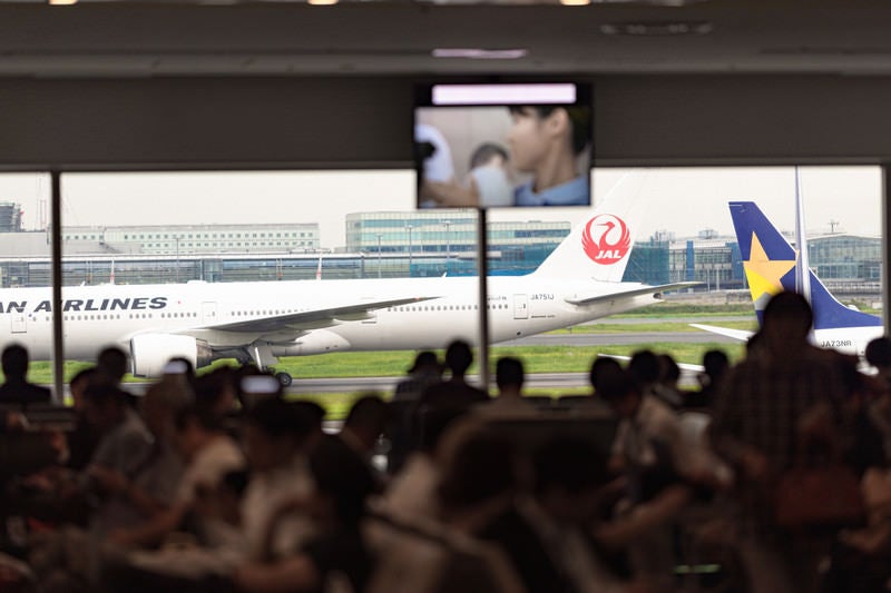 空港の出発ロビーで待つ人々の写真