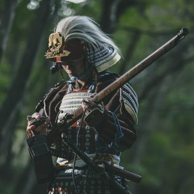 火縄銃に着火する侍の写真