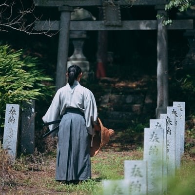 鳥居へ向かう武士の後ろ姿の写真