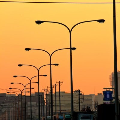 産業道路と連なる街灯（夕焼け）の写真