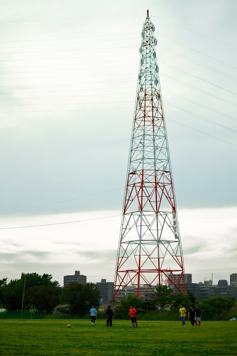 送電線と河川敷の光景の写真