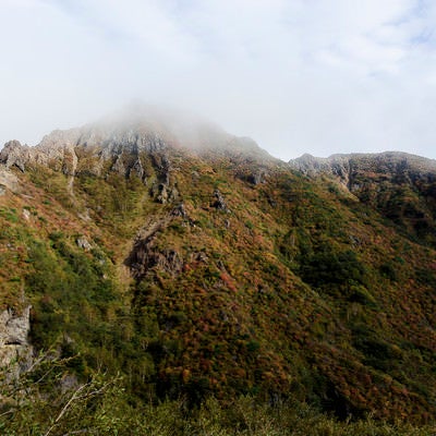 雲に包まれる紅葉した那須朝日岳（あさひだけ）の写真