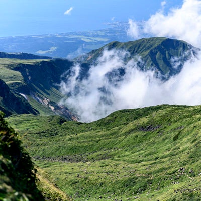 雲が湧き上がる鳥海山山頂の写真