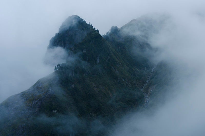 雲の中から浮かび上がる天狗岩（巻機山）の写真