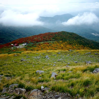 月山ロープウェイと紅葉の山肌の写真