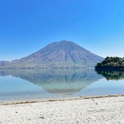 砂浜の向こうに浮かぶ男体山（栃木県日光市）の写真