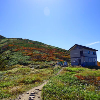 大朝日岳避難小屋と山頂方面の景色の写真