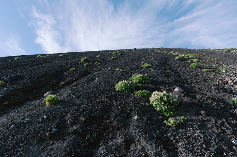 火山の斜面と雲の空（岩手山）の写真