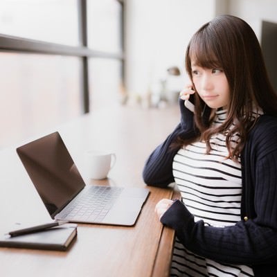 クライアントへ確認の電話を入れるIT女子の写真