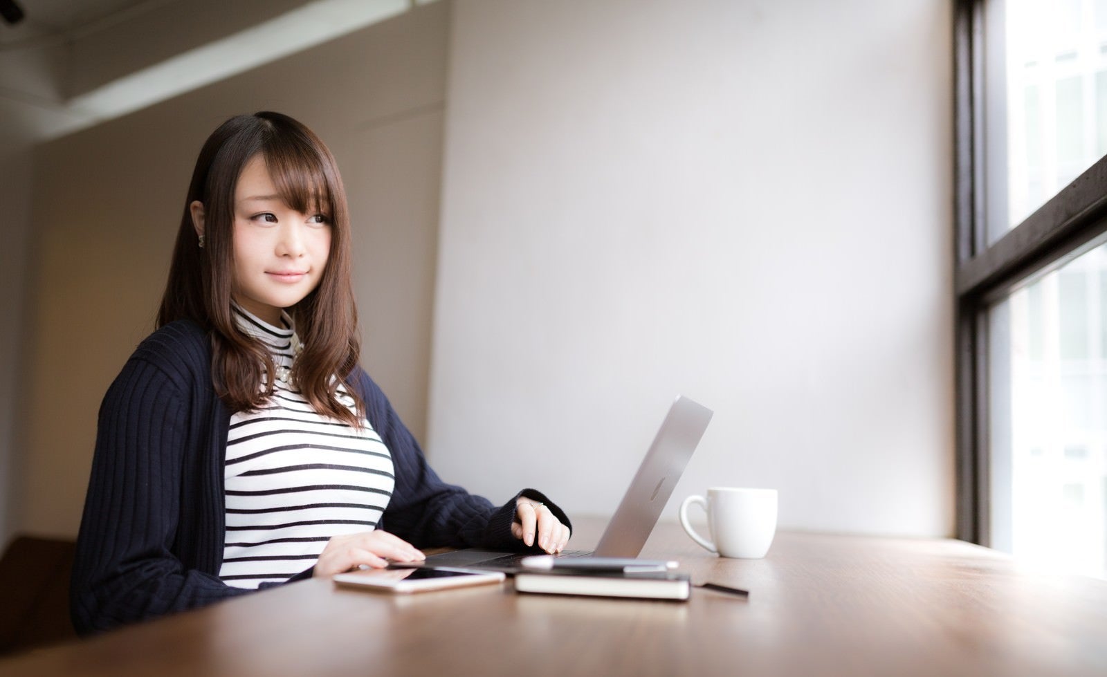 「気分を変えてカフェで作業をするノマド女子」の写真［モデル：茜さや］