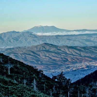 晩秋の山々と霞む空の御嶽山の写真