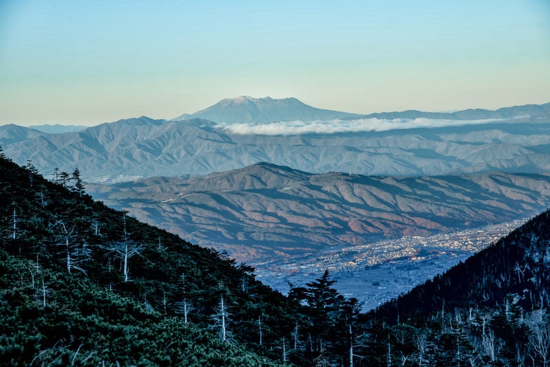 晩秋の山々と霞む空の御嶽山の写真