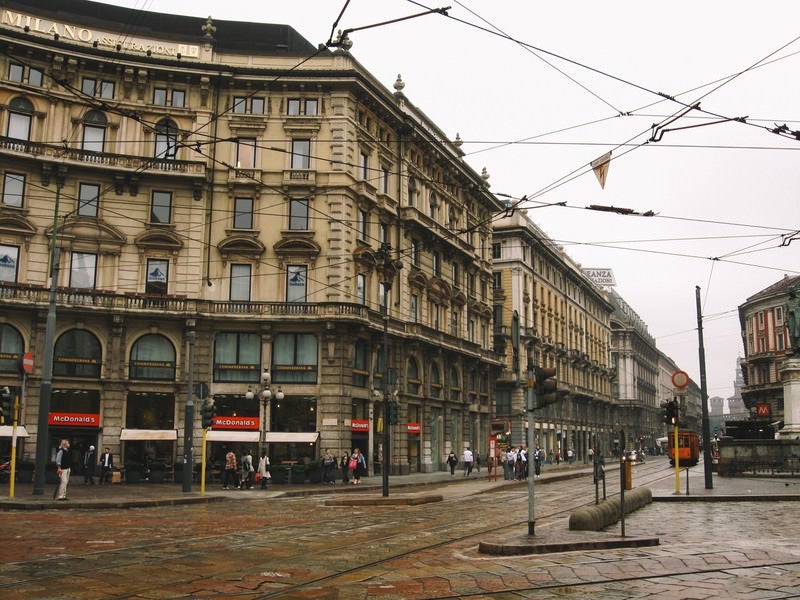 ミラノの通りと共に張りめぐる電線と街並み（イタリア）の写真