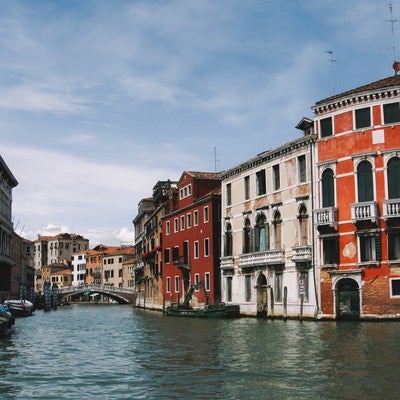 ヴェネツィアにある川に浮かぶ小船と街並み（イタリア）の写真