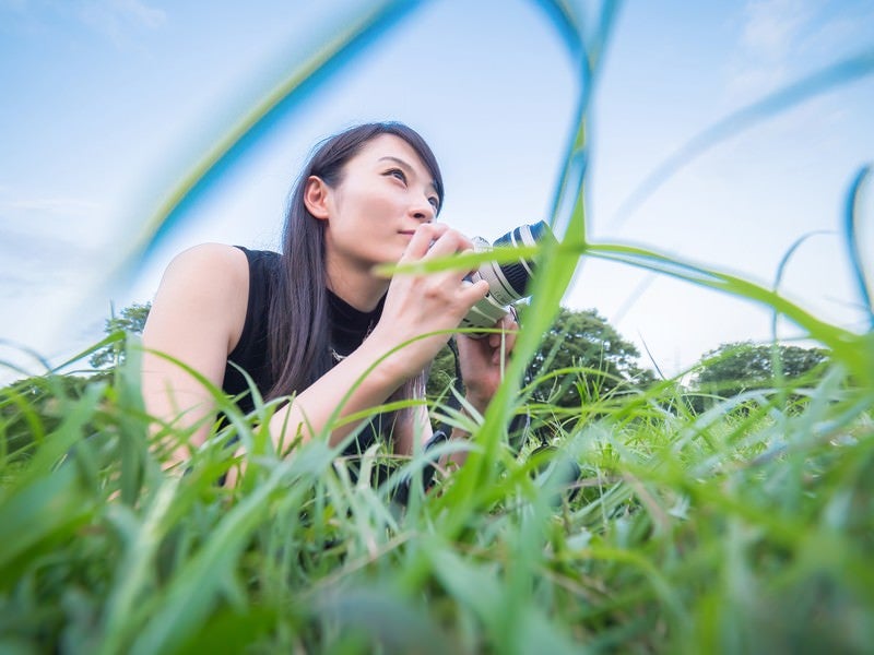 ローアングルから撮影するカメラ女子の写真