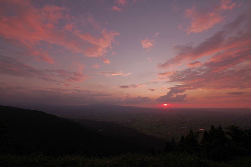 日没前の夕焼けに染まる散居村の写真