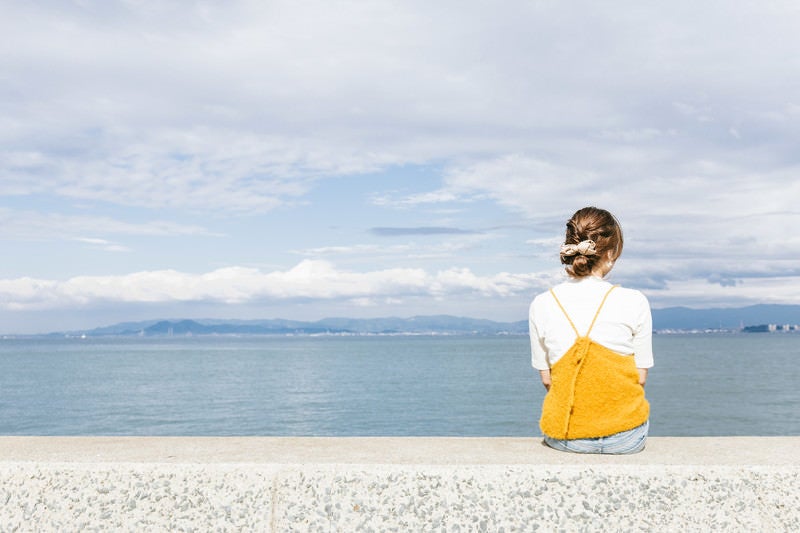 埠頭に座る女子の写真