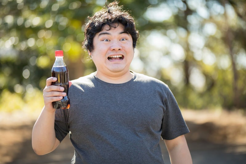 コーラ片手に不気味な笑みを浮かべる太っちょさんの写真