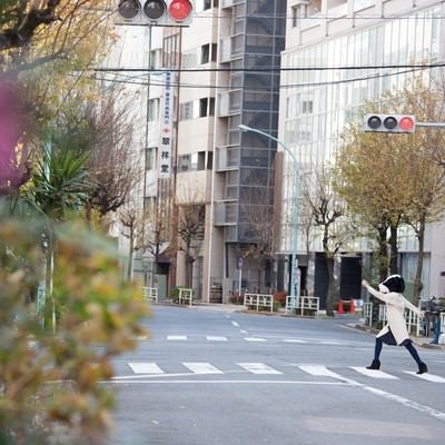 横断歩道を元気よく歩く牛人間の写真