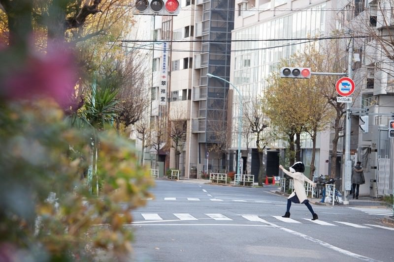 横断歩道を元気よく歩く牛人間の写真