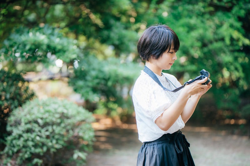 スナップ撮影を楽しむカメラ女子の写真