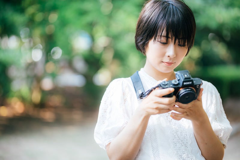 撮影したら、その場で画像を確認するカメラ女子の写真