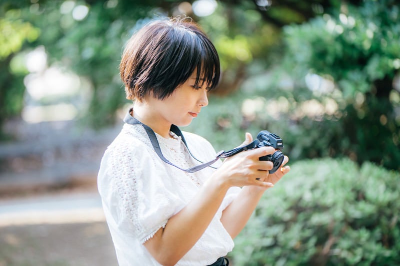 撮影した画像を確認してご満悦のカメラ女子の写真