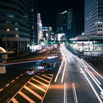 夜の交差点を行き交う車の写真