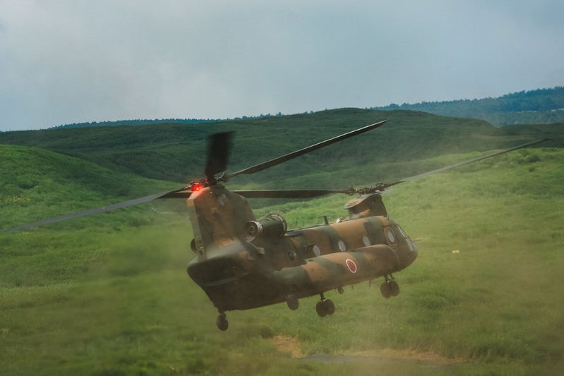 自らのダウンウォッシュで巻き上げた砂埃の中着陸するチヌーク（CH-47）の写真