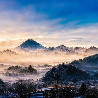 朝霧が漂う雪山の写真