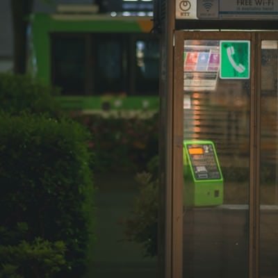 雨に濡れる電話ボックスの写真