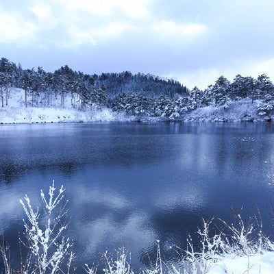 山間の沼と雪景色の写真