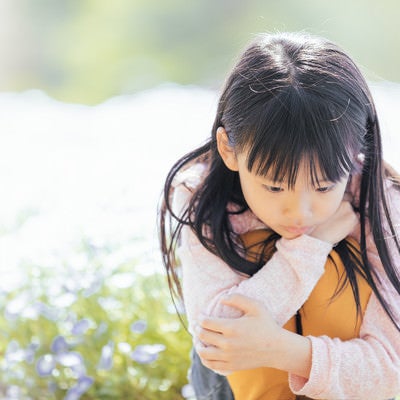 お花畑でうつむく女の子の写真